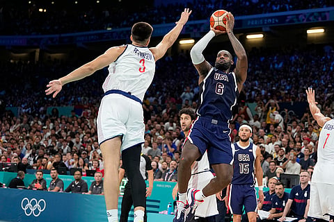LeBron James shoots as Filip Petrusev defends